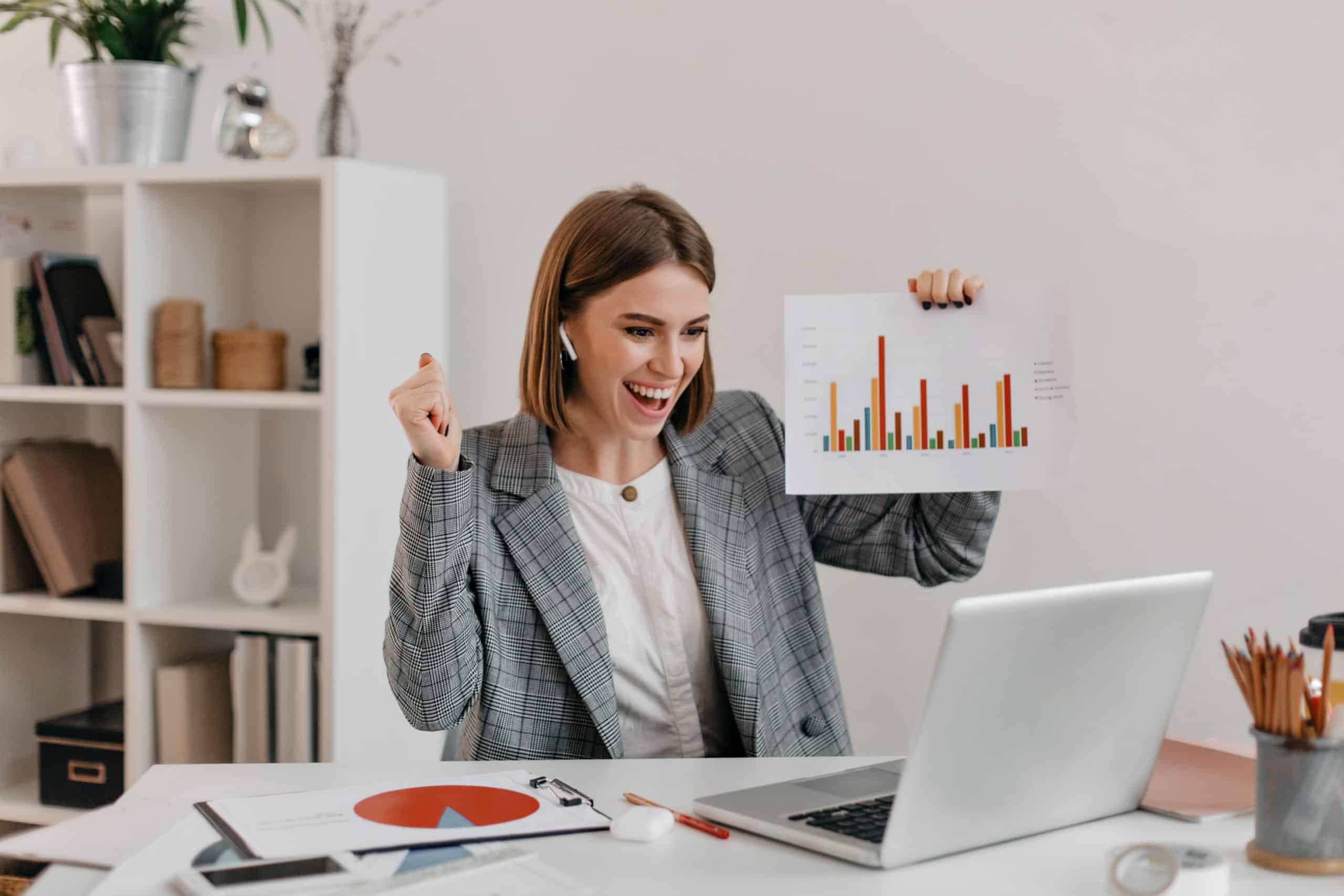 Close-up shot of happy business woman in stylish outfit. Girl in high spirits demonstrates chart via Skype. Workforce transformation